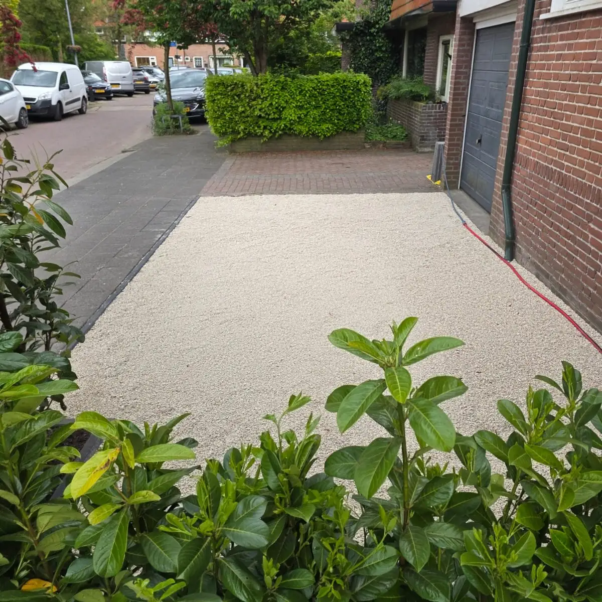Voortuin met laurierhaag en nieuwe bestrating